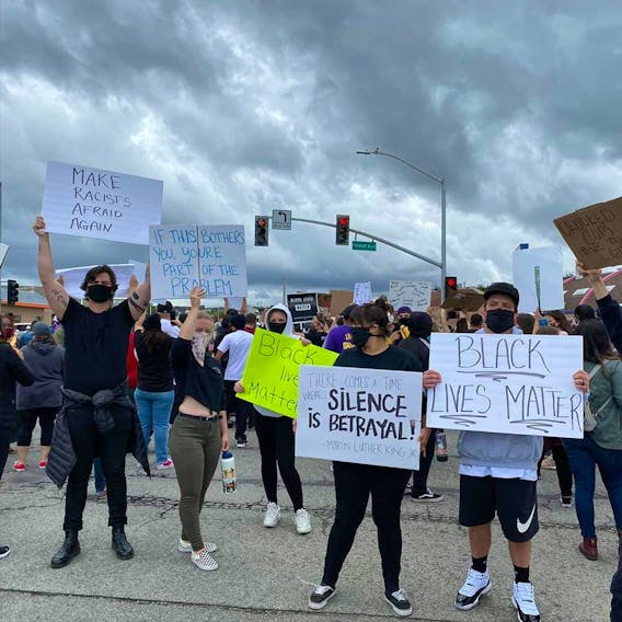 Protesters block an intersection in Seaside, Calif., near former Islander Michelle Brassard's workplace.
