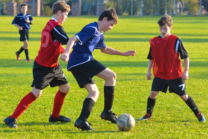 M.E. Callaghan Cougars’ Brogan Chaisson, centre, looks to manoeuvre his way around Summerside Intermediate School Owls teammates Aaron Trenholm, left, and Cyrus Cormier. The action took place during the recent P.E.I. School Athletic Association Intermediate AA Boys Soccer League’s West Division semifinal at the Summerside Intermediate School Field. The Owls punched their ticket to the provincial semifinals with a 7-0 victory.