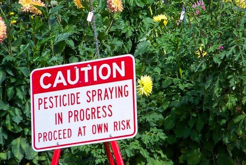 A sign warning of pesticides spraying.