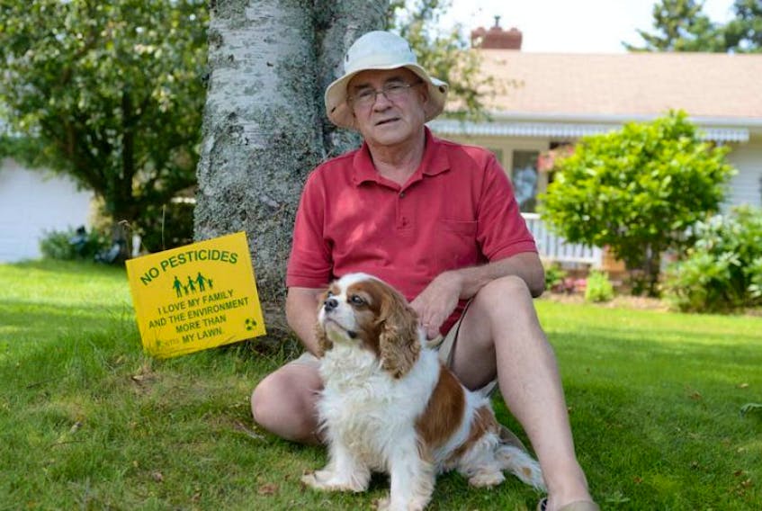 Retired UPEI professor and his dog Alfie relax on he lawn of his home in Stratford Saturday. He wants the provincial government to ban the use cosmetic pesticides near schools, senior homes and other special areas.&nbsp;