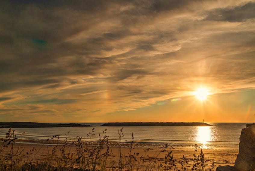 In this photo, you can see the sun dogs on either side of the sun; the one to the right of the sun is showing some colour.  Debbie Roberts snapped this beauty at Port Maitland Beach, Nova Scotia.