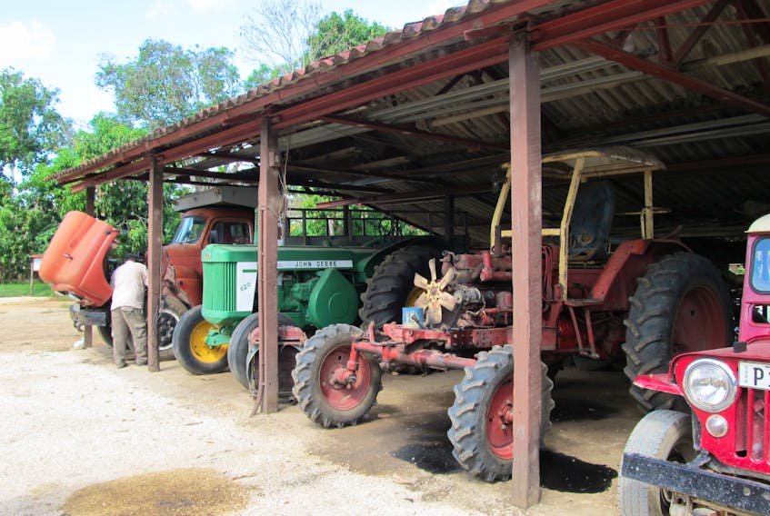 A farmhand maintains the half-decade old equipment used every day on this farm in Villa Maria, near Maron City, Cuba.  The farmer told me his favourite tractor is the 1956 John Deere you see in this photo.