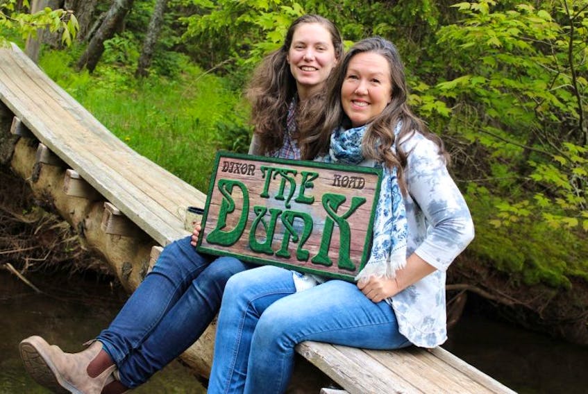 Catherine MacLellan, left, and Melanie Mills, sit on the small, rickety bridge that lays over the Dunk River.