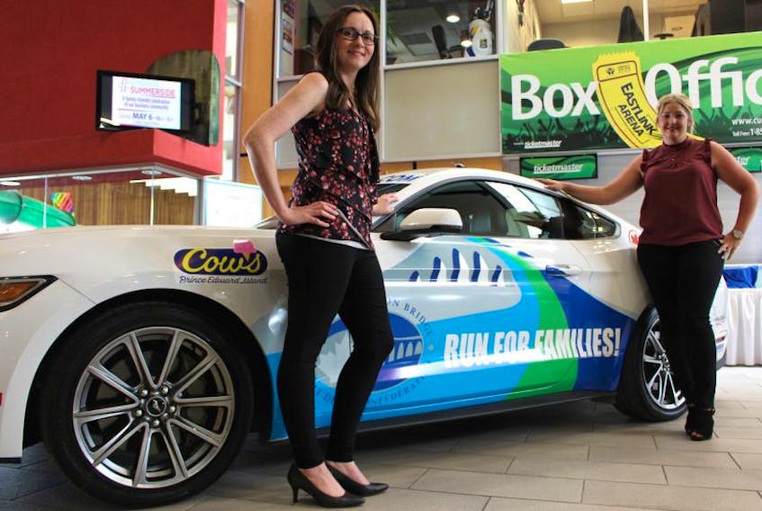 Danette Murray, left, and Jenna Muttart with the BridgeFest 150 car that’s up for grabs for participants to win. Murray is BridgeFest 150’s project administrator and Murray is the graphic designer.