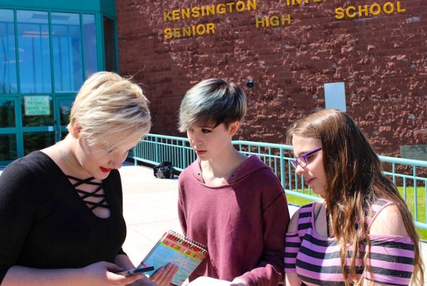 Josie Green, left, Skye MacAusland and Rebecca Wiegers discuss a walkout they are organizing at Kensington Intermediate and Senior High school for next Tuesday. The trio of Grade 11 students decided to take action after the government’s recent announcement about teacher reallocations.