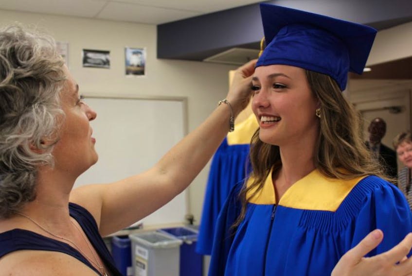 Janice Broderick, left, a teacher at Kinkora Regional High School, adjusts graduating student Colby Bell's tassel on her graduation cap.