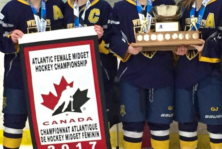 The Mid-Isle Wildcats accept the championship trophy and banner after winning the Atlantic midget AAA female hockey title in Lantz, N.S., on Sunday afternoon. The Wildcats pulled out a2-0 decision over the Northern Subway Selects from Nova Scotia in the gold-medal game. From left: Kennedy Francis, assistant captain; Makayla Larsen, captain; Taylor Gillis, assistant captain and the tournament’s top scorer, and Alexis Mulligan, assistant captain.