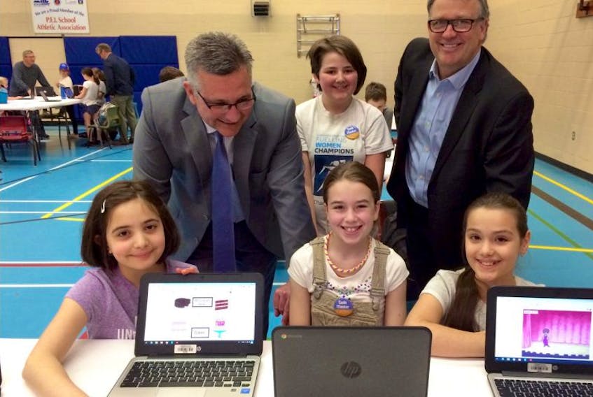 Students who showcased their video game creations at the Provincial Coding Arcade, were (from left) Golnar Saegh, Grade 4 at West Kent; Faith Pineau, Grade 6 at Eliot River; Alesia Alimema, West Kent, and Zoe Rankin-Myshrall, Grade 6, at Eliot River (standing). Looking on are (from left) Economic Development Minister Health MacDonald, whose department helped to fund the Coding Quest program, and Education Minister Doug Currie.
