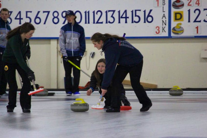 Skip Justine Comeau releases the rock as second stone Brigitte Comeau, left, and lead Keira McLaughlin get ready to sweep during the women’s title match of the 2016 Fall Fling junior cashspiel in Summerside on Sunday.