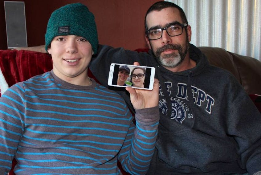 Pacey MacIsaac (left) and father Stephen with a photo of Pacey and Becca Schofield. MacIsaac has been encouraging others to do kind things for others in Schofield’s name. Schofield in dying of cancer.