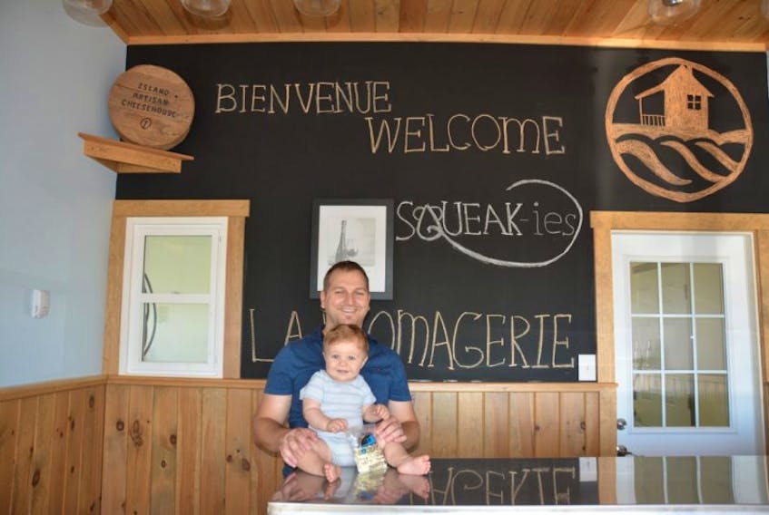 Mathieu Gallant, the owner of The Island Artisan Cheesehouse in Mont-Carmel, with his 11-month-old son, Bruno. Gallant said, “I call it a family business because we support the family farm. My dad milks the cows and I make the cheese.”
