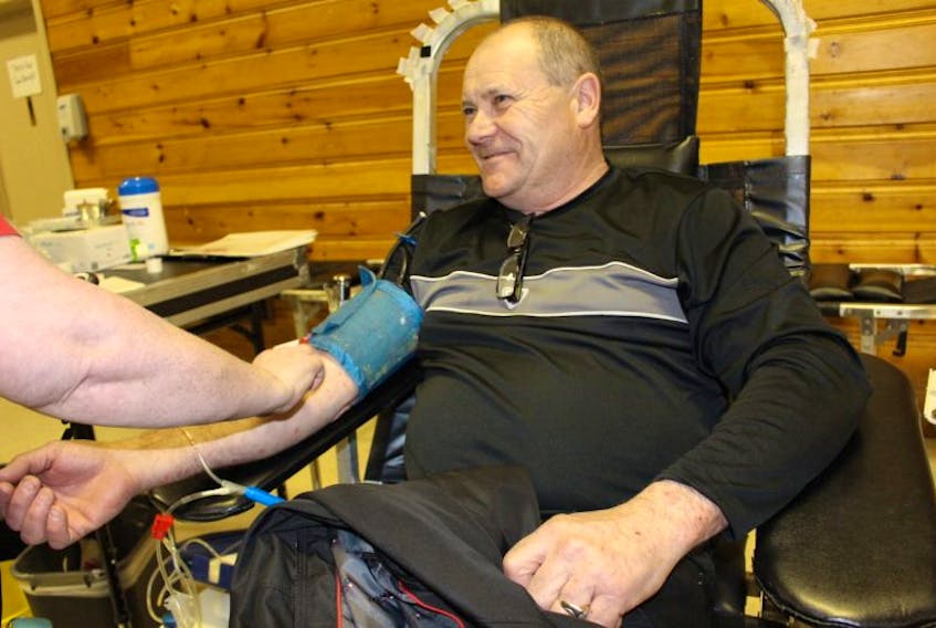 Paul Vandervelden watches as a nurse cleans his arm before taking a blood donation at the Miscouche Blood Clinic on Tuesday.