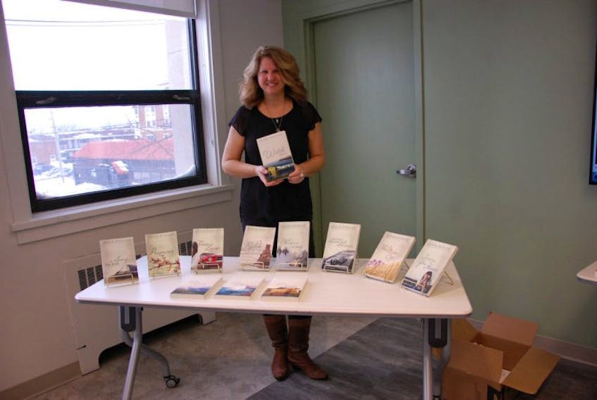 Award-winning Summerside author and filmmaker Susan Rodgers, holds up her latest and book in the Drifters series “Watch Over Me,” during a book reading at the Summerside Rotary Library Saturday afternoon.