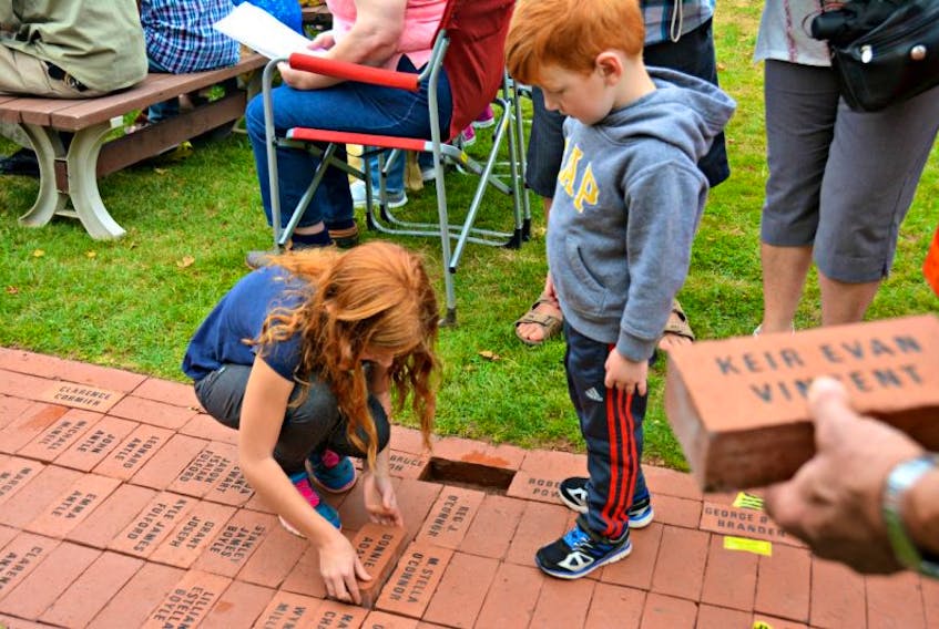 Lexie Delaney, 9, and Cohen, 4, laid down an engraved brick in special memory of their grandfather during the annual brick laying ceremony at the International Children’s Memorial Place on Sunday afternoon.