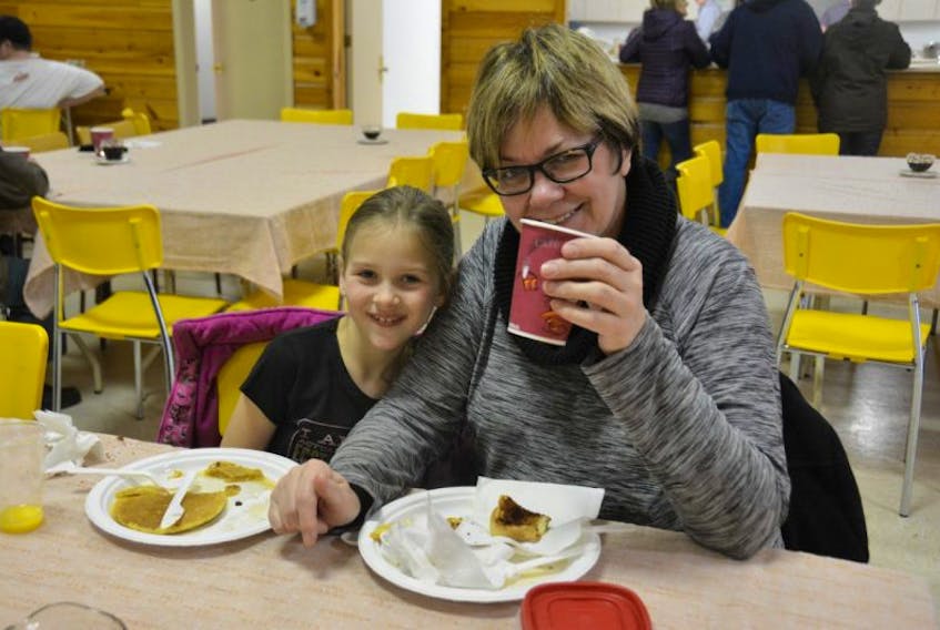 Deb Searle and her granddaughter Ava Searle, 8, enjoy a pancake breakfast served with maple syrup at the Miscouche Family Day event, on Saturday morning.