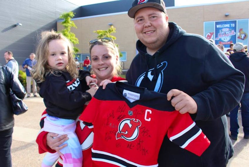 Ryan Mann shows off his New Jersey Devils jersey along with his wife and daughter during Hockeyville at Credit Union Place in Summerside on Monday, Sept. 25, 2017. An NHL exhibition game between the Devils and Ottawa Senators was part of the prize won by O'Leary in the Hockeyville contest. 