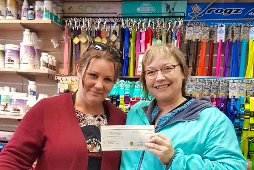 Keeping Cats Homed forerunner, Lorri Burnell, right, accepts a cheque from Summerside’s Global Pet Foods staffer for over $1,000.
