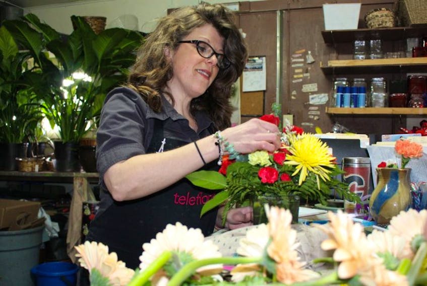 Elise Arsenault, who has worked for the business for seven years, puts together a flower arrangement in the backroom of Kelly’s Flower Shoppe currently located at 297 Water Street. The store will move to 505 Granville Street and is set to open April 3.