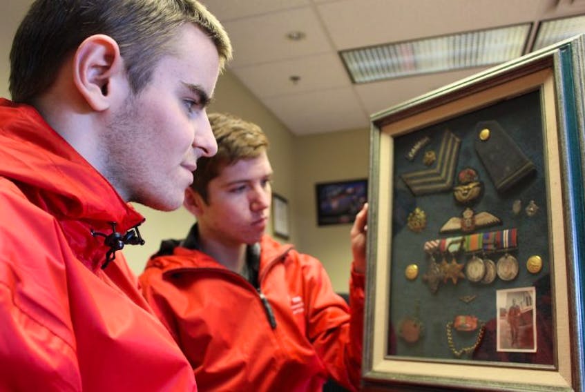 Dylan Corbett, left, and Jesse Ford look at Thomas Haughton Gordon’s medals. Gordon was a night fighter pilot in the Second World War.