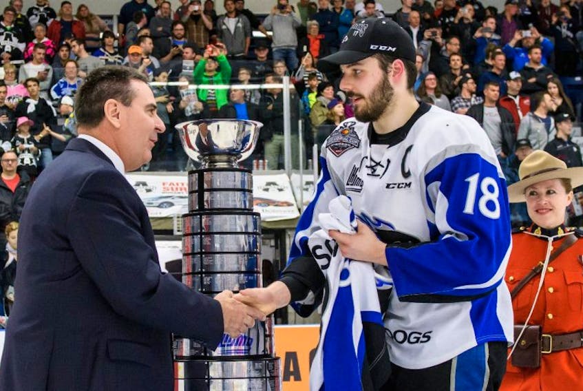 Saint John Sea Dogs captain Spencer Smallman shakes hands with Quebec Major Junior Hockey League commissioner Gilles Courteau before accepting the President’s Cup. Smallman is holding the jersey of teammate Oliver Felixson, who is back in his native Finland receiving treatment after he was recently diagnosed with Hodgkin’s lymphoma.