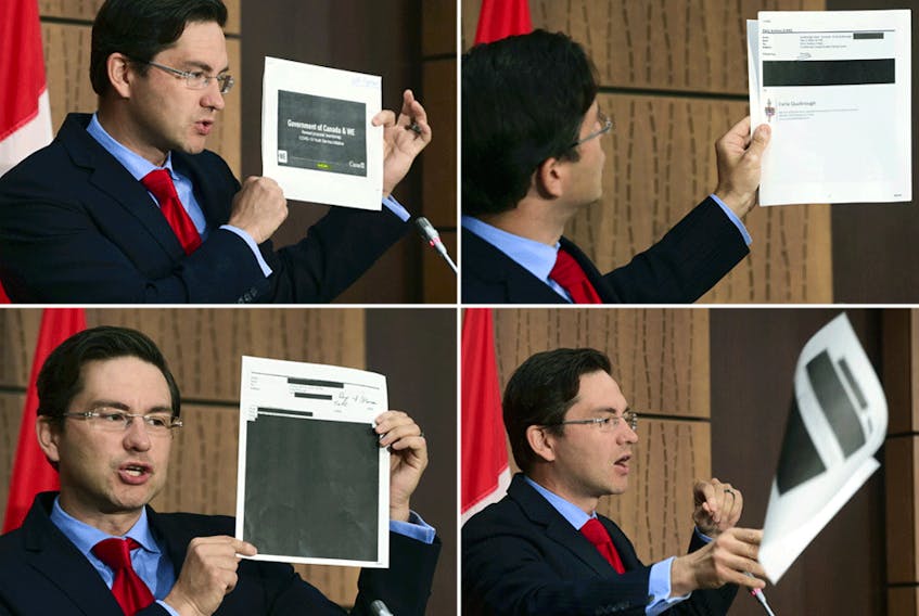 Conservative MP Pierre Poilievre holds up documents relating to the WE scandal  that were tabled by the government at the House of Commons finance committee, during a press conference on Wednesday, Aug. 19, 2020.