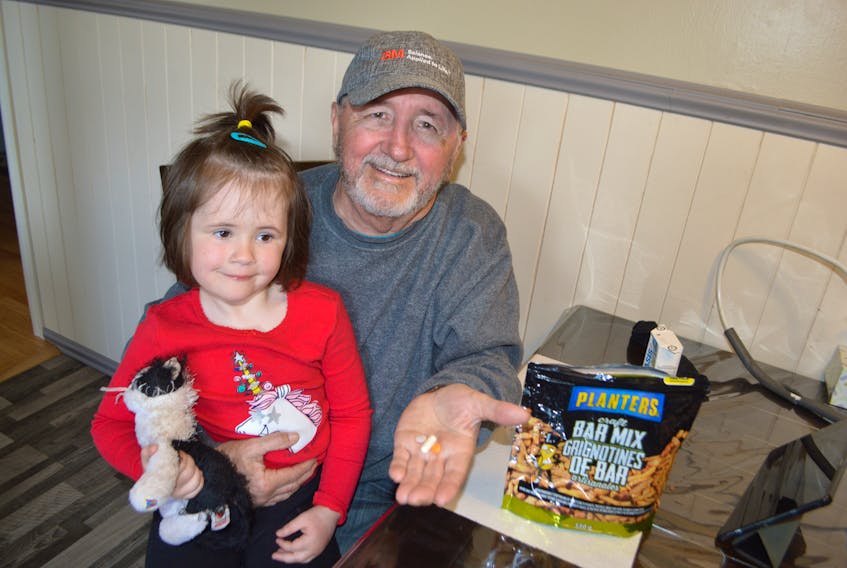 Stan Peach of Glace Bay and his great-granddaughter Summer, 4, showing pills found a in a bag of Planter’s Bar Mix their family was eating, back in May. Peach said the identification of the pills is certainly a concern, however he’s grateful Johnvince Foods and the Canadian Food Inspection Agency took his complaint seriously and investigated the incident thoroughly. Sharon Montgomery-Dupe/Cape Breton Post