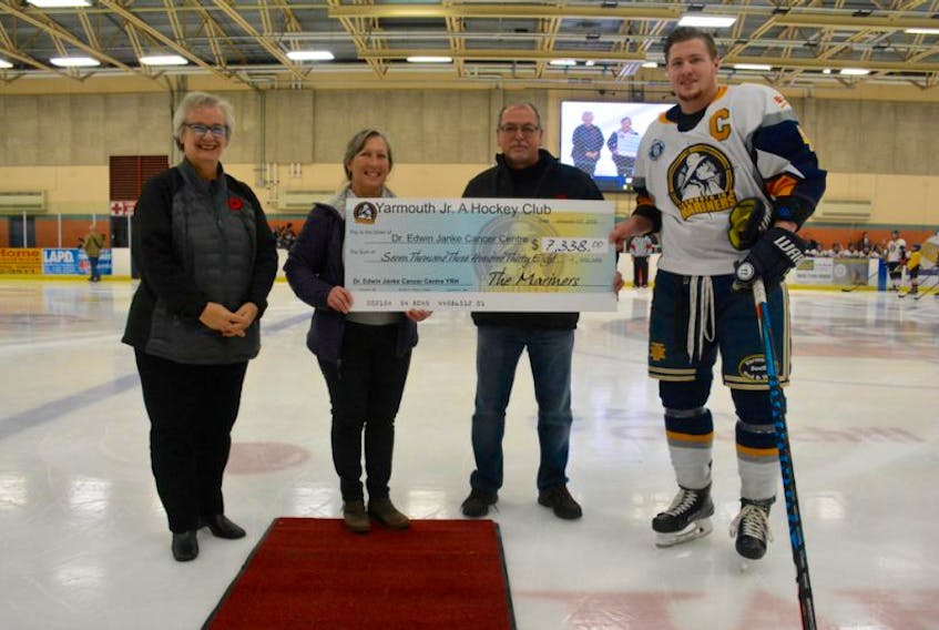 Keith Condon, an owner of the Mariners, and Mariners captain Ryan Daley, present a cheque in the amount of $7,338 to Darolyn Walker and Heather Campbell of the Dr. Edwin Janke Cancer Centre. The money was raised through Pink in the Rink.