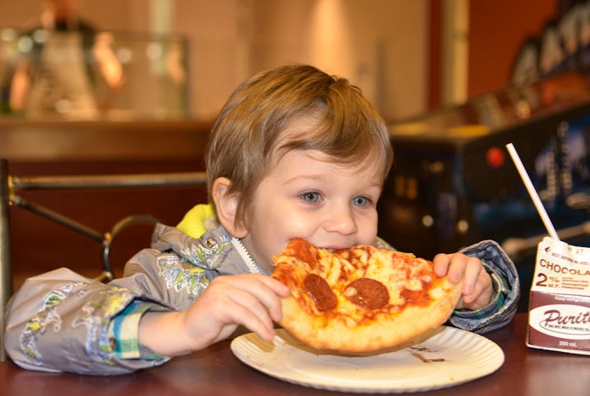 Four-year-old Sander McGrath of Charlottetown takes a big bite out of a slice of Pepperoni pizza at Satellite Pizza on Friday. TERRENCE MCEACHERN/THE GUARDIAN