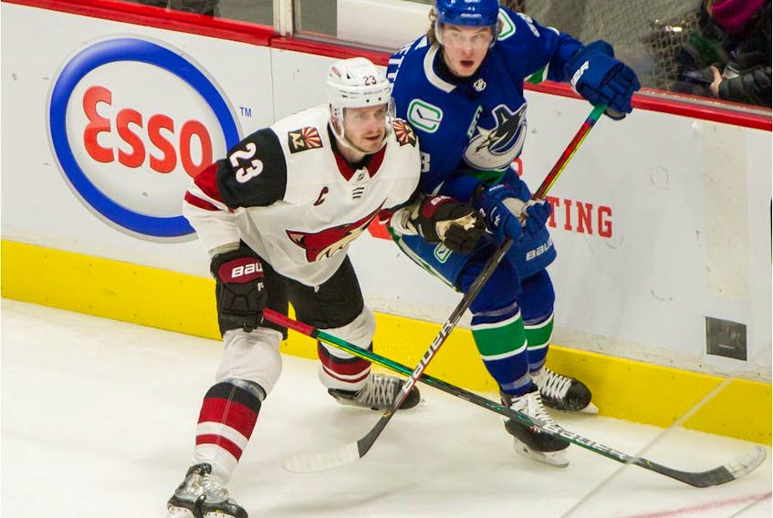Veteran defenceman Oliver Ekman-Larsson of the Arizona Coyotes, left, sticks close to Adam Gaudette of the Vancouver Canucks during NHL action earlier this year. Is it possible the two could become teammates next season?
