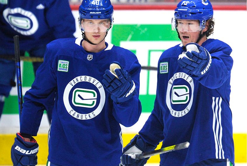 New Canuck Tyler Toffoli, right, discusses a few things with Elias Pettersson during the NHL team's Tuesday practice at Rogers Arena in Vancouver.
