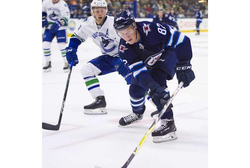Winnipeg Jets Mason Appleton reaches for a loose puck while battling with Vancouver Canucks Guillaume Brisebois during NHL preseason hockey action at the Young Stars Classic held at the South Okanagan Events Centre in Penticton, BC, September, 8, 2017. 