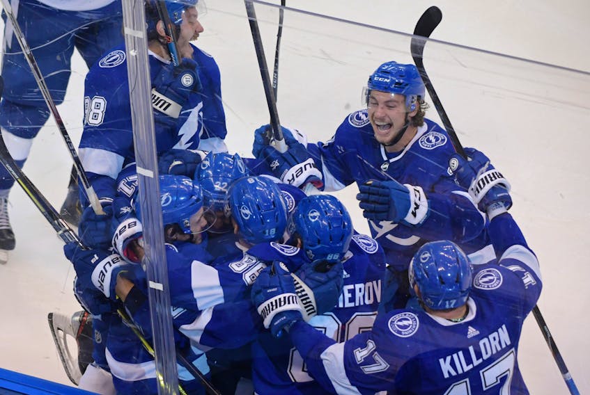Tampa Bay Lightning players celebrate Brayden Point’s game-winning goal against the Columbus Blue Jackets in the fifth overtime of the opening game of their Eastern Conference playoff series on Tuesday.  
