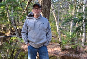 Geoff Ponee stands in front of the brook just beyond his property on Hescott Street in Elmsdale. The sewer plant and septic bed for a proposed mobile home park off the Old Truro Road would be located to the far side of the brook.