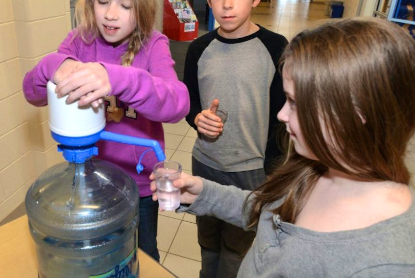 <span class="art-imagetext">Kate Lowe pumps water for Mary Soucy and Andrew Hrickyw at Ecole St. Augustin in this recent file photo. The school goes through over 200 water bottles every three weeks from five water stations throughout the school.</span>
