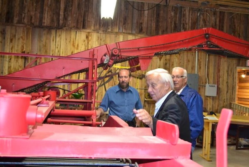 <p>P.E.I. Potato Board president, Gary Linkletter, left, and Arlington grower Allison Dennis, right, look on as Donnie Allan explains the features of the first two-row potato harvester he ever built It is on display at the Canadian Potato Museum in O’Leary. Dennis and Allan are two of the potato industry builders featured in a new video series on the history of the P.E.I. Potato industry. The video was launched Wednesday at the potato museum.</p>