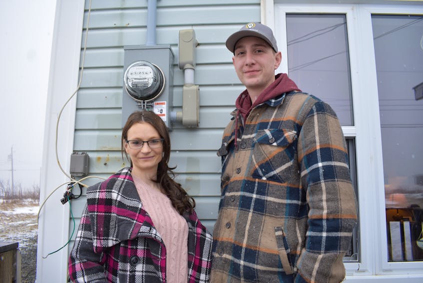 Alyssa Brown, left, and Devon Murray stand next to the electrical service stack on the side of Brown’s home in Glace Bay. Murray, the owner of Devon’s Electrical in River Ryan, helped the young mother of an infant son when he learned she was left without power after a blizzard tore the stack from the house and Brown couldn’t afford to pay for the repairs. Chris Connors/Cape Breton Post

