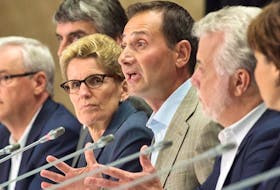 Prince Edward Island Premier Robert Ghiz is flanked by Ontario Premier Kathleen Wynne, left, and Quebec Premier Philippe Couillard, right, at the closing news conference of the annual Council of the Federation meeting in Charlottetown on Friday, August 29, 2014.