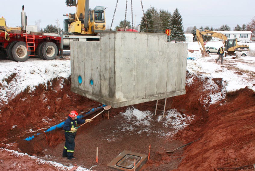 A worker from Maritech Construction Inc. guides the last of four pressure reducing valve chambers into place. Its installation next to the MacDonald Road marks a milestone in the Town of Amherst’s $5.5-million reservoir replacement project.