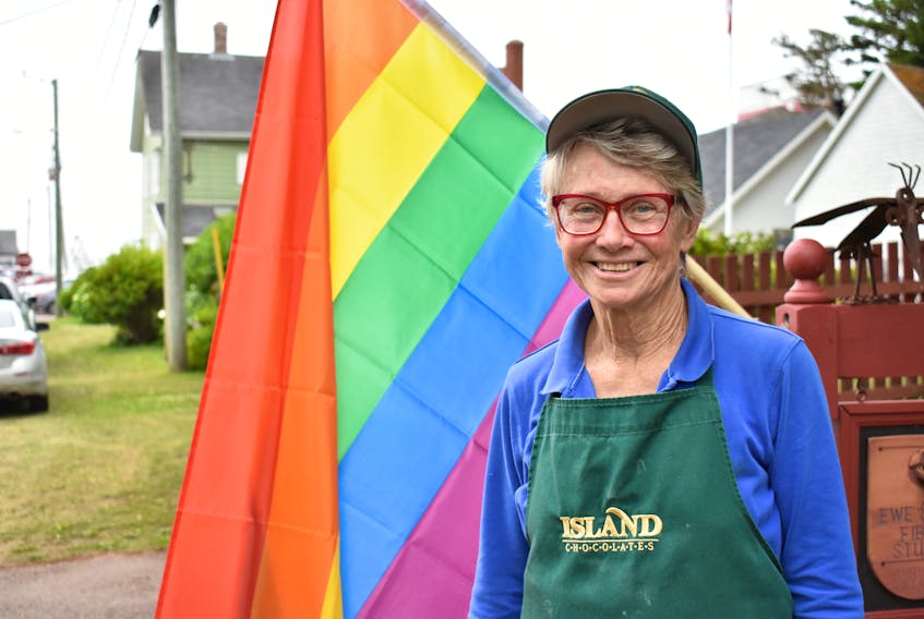 Jeanne Sullivan, one of the organizers of Pride by the Sea, stands in front of one of the many Pride flags waving in Victoria on July 29.