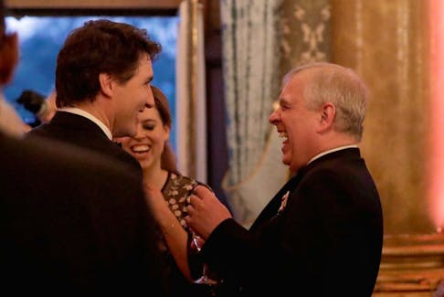 Britain's Princess Beatrice, centre background, and her father Prince Andrew, right, share a joke with Canadian Prime Minister Justin Trudeau during a reception for the Queen's Dinner, part of the Commonwealth Heads of Government Meeting (CHOGM) at Buckingham Palace in London, Thursday, April 19, 2018. 
