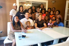 Members of Daneesha Provo's extended family surround her at her uncle's house in East Preston as she signs her contract to play professional basketball in Germany. (CONTRIBUTED)