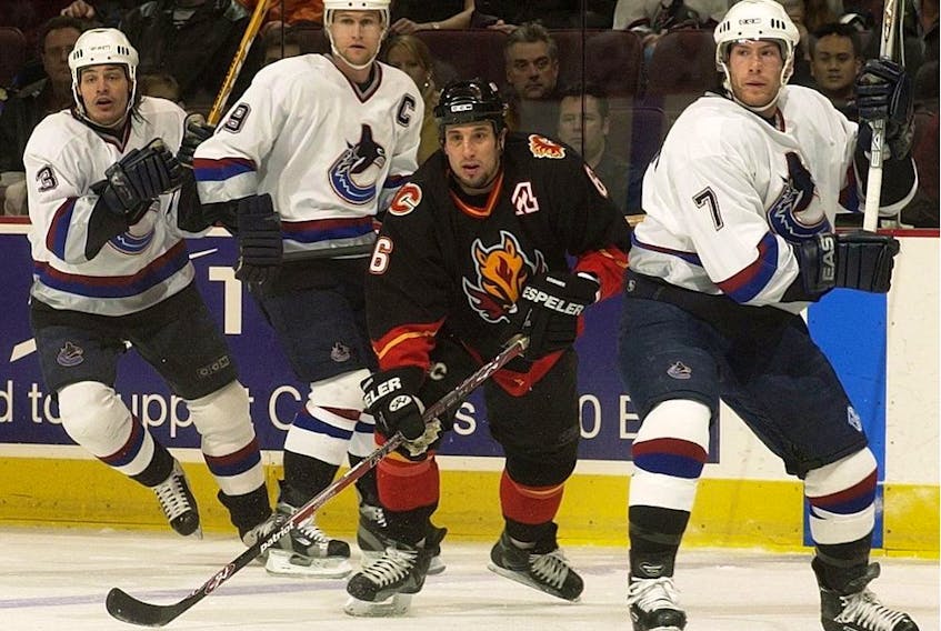 Vancouver Canucks Brent Sopel, left, Markus Naslund, centre, and Brendan Morrison surround Bob Boughner of the Calgary Flames in NHL action in December of 2002.
