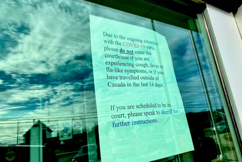 A message on the door of the Yarmouth Justice Centre telling people that if they're traveled outside of the country recently they are not allowed inside the courtroom. TINA COMEAU PHOTO