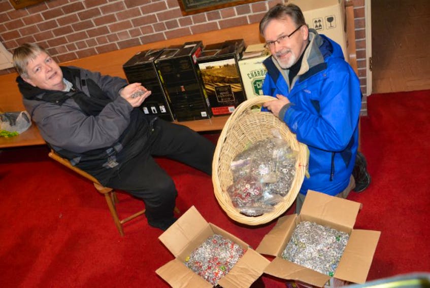<p>Yarmouth resident Cheryl Burchell and David Sollows, a member of Beacon United Church, with the collection of pull tabs brought in by Shelburne resident Carl Thompson. There were boxes and boxes of the tabs. Unopened ones are behing Burchell and Sollows.</p>