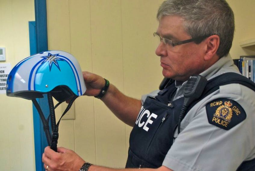 Queens District RCMP Const. Rob James demonstrates the correct way to wear a helmet. Police say with the opening of the new Mersey Skate Park slated for next month, they will be cracking down on helmet use.
