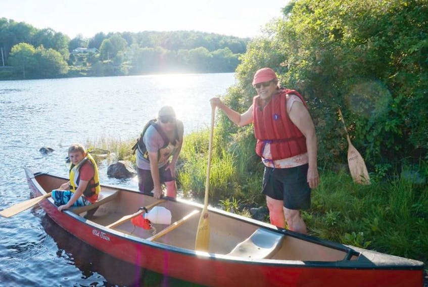 Steve Oliver (centre) helps Lincoln Godfrey (left) and Ruth Smith (right) prepare for their canoe ride. 