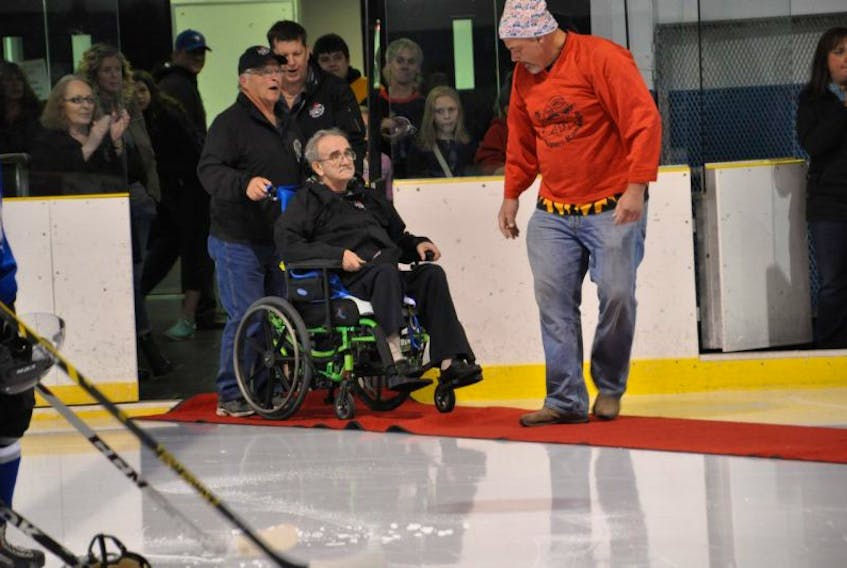 Ted Huskins wheels his brother Reg Huskins onto the red carpet to officially drop the puck for the first game of the Prince Rupert Rampage. Ted took his brother, who has dementia, from a nursing home where he was barely functioning to the game, where Reg received a standing ovation.