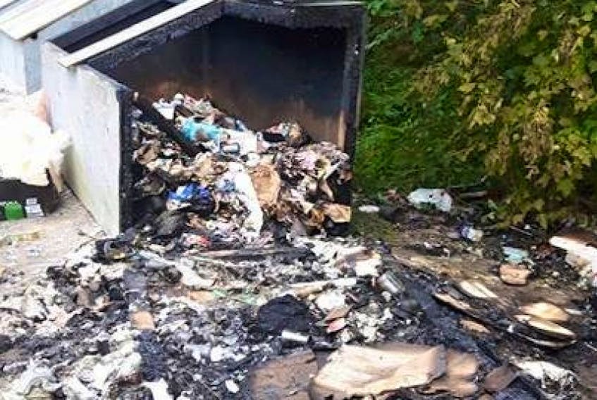 The remains of a garbage bin fire by Gulch Road the day after. RCMP are looking for arsonists who started six