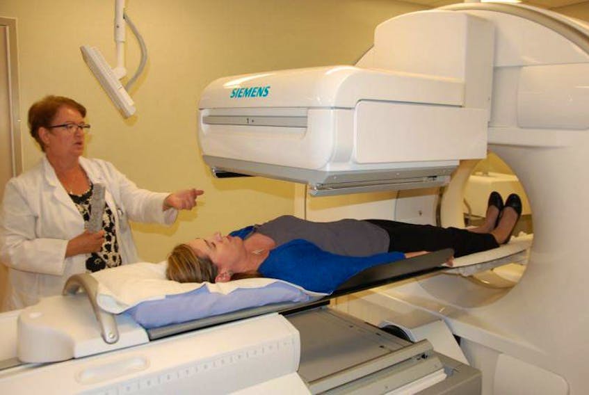 Corinne Bell, a nuclear medicine co-ordinator with the QEH, demonstrates the hospital's SPECT/CT camera with Sheila Driscoll, QEH Foundation. 