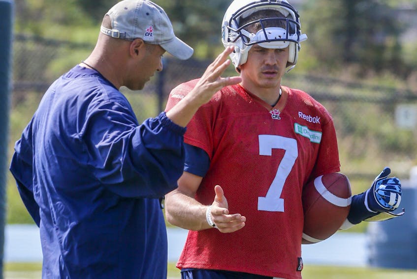 Former Toronto Argonauts head coach Scott Milanovich talks with quarterback Trevor Harris at Downsview Park during practice in Toronto in this file photo from Sept. 24, 2015. The pair has been reunited on the Edmonton Eskimos.